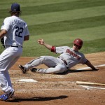 Arizona Diamondbacks' Aaron Hill, right, scores past Los Angeles Dodgers starting pitcher Clayton Kershaw on a single on Paul Goldschmidt during the third inning of a baseball game in Los Angeles, Thursday, Sept. 24, 2015. (AP Photo/Chris Carlson)