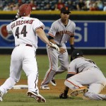 Arizona Diamondbacks' Paul Goldschmidt (44) collides with San Francisco Giants' Joe Panik, right, as Panik attempts to field a grounder, as Giants' Ehire Adrianza watches  during the fourth inning of a baseball game Tuesday, Sept. 8, 2015, in Phoenix.  Diamondbacks' Goldschmidt was safe at second base on the play.  (AP Photo/Ross D. Franklin)