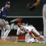 Arizona Diamondbacks' A.J. Pollock, middle, slides safely into second base with a double as San Diego Padres' Cory Spangenberg, left, looks for the baseball that was thrown over his head, but right to pitcher James Shields, right, during the first inning of a baseball game, Monday, Sept. 14, 2015, in Phoenix. (AP Photo/Ross D. Franklin)