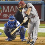 Arizona Diamondbacks' Paul Goldschmidt, right, hits a solo home run as Los Angeles Dodgers catcher Yasmani Grandal watches during the eighth inning of a baseball game, Monday, Sept. 21, 2015, in Los Angeles. (AP Photo/Mark J. Terrill)
