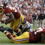 Washington Redskins running back Matt Jones (31) dives into the end zone over teammate guard Shawn Lauvao (77) for a touchdown after breaking a tackle from St. Louis Rams middle linebacker James Laurinaitis (55) during the second half of an NFL football game in Landover, Md., Sunday, Sept. 20, 2015. (AP Photo/Patrick Semansky)