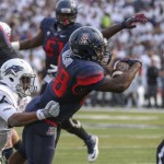 Arizona's Nick Wilson (28) scores against Nevada's Kendall Johnson (26) during the first half of an NCAA college football game in Reno, Nev., on Saturday, Sept. 12, 2015. (AP Photo/Cathleen Allison)