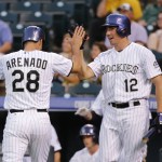 Colorado Rockies' Nolan Arenado (28) is congratulated by teammate Matt McBride (12) after scoring on a Ben Paulsen RBI double against the Arizona Diamondbacks during the first inning of the second game of a baseball doubleheader Tuesday, Sept. 1, 2015, in Denver. (AP Photo/Jack Dempsey)