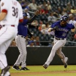 Colorado Rockies' Charlie Blackmon (19) rounds third to score on a base hit by teammate Carlos Gonzalez as Arizona Diamondbacks starting pitcher Robbie Ray (38) looks for the throw during the first inning of a baseball game, Tuesday, Sept. 29, 2015, in Phoenix. (AP Photo/Matt York)