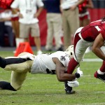 Arizona Cardinals wide receiver Larry Fitzgerald (11) is tripped up by New Orleans Saints free safety Rafael Bush (25) during the second half of an NFL football game, Sunday, Sept. 13, 2015, in Glendale, Ariz. (AP Photo/Ross D. Franklin)