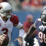 Arizona Cardinals quarterback Carson Palmer (3) scrambles away from Chicago Bears defensive tackle Jarvis Jenkins (96) during the first half of an NFL football game, Sunday, Sept. 20, 2015, in Chicago. (AP Photo/Michael Conroy)