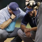San Diego Padres head trainer Todd Hutcheson, left, checks on pitcher James Shields, right, as he grimaces after being hit in the arm by a line drive hit by Arizona Diamondbacks' Brandon Drury during the seventh inning of a baseball game Monday, Sept. 14, 2015, in Phoenix. (AP Photo/Ross D. Franklin)