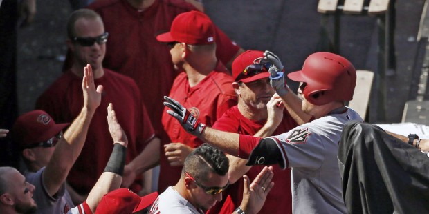 Arizona Diamondbacks' Phil Gosselin is congratulated by teammates as he enters the dugout after hit...