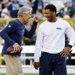 Seattle Seahawks head coach Pete Carroll has some fun with quarterback Russell Wilson before an NFL football game against the Green Bay Packers Sunday, Sept. 20, 2015, in Green Bay, Wis. (AP Photo/Mike Roemer)