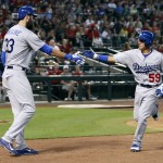 Los Angeles Dodgers' Ronald Torreyes (59) is congratulated by Scott Van Slyke after scoring against the Arizona Diamondbacks on an RBI-single by Adrian Gonzales during the seventh inning of a baseball game Sunday, Sept. 13, 2015, in Phoenix. The Dodgers defeated the Diamondbacks 4-3. (AP Photo/Ralph Freso)