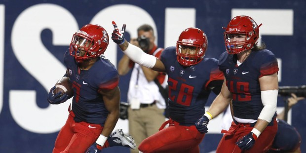 Arizona safety Jamar Allah (7) celebrates with Anthony Lopez (28) and Haden Gregory after scoring a...