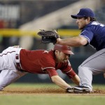 Arizona Diamondbacks' A.J. Pollock, left, dives safely back to first base as San Diego Padres' Brett Wallace, right, waits for the late pickoff throw during the first inning of a baseball game Wednesday, Sept. 16, 2015, in Phoenix. (AP Photo/Ross D. Franklin)