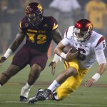 Southern California's Cody Kessler (6) dives for a first down as he gets past Arizona State's Antonio Longino (32) during the first half of an NCAA college football game Saturday, Sept. 26, 2015, in Tempe, Ariz. (AP Photo/Ross D. Franklin)