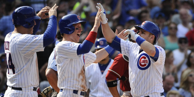 Chicago Cubs' Anthony Rizzo (44), left, and Chris Coghlan, center, high-five teammate Miguel Monter...