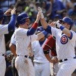 Chicago Cubs' Anthony Rizzo (44), left, and Chris Coghlan, center, high-five teammate Miguel Montero after he hit a grand slam off Arizona Diamondbacks' Matt Reynolds pitching in the sixth inning of a baseball game on Sunday, Sept. 6, 2015, in Chicago. (AP Photo/Matt Marton)