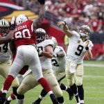 New Orleans Saints quarterback Drew Brees (9) throws over Arizona Cardinals defensive end Cory Redding (90) during the first half of an NFL football game, Sunday, Sept. 13, 2015, in Glendale, Ariz. (AP Photo/Ross D. Franklin)