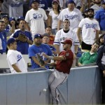 Arizona Diamondbacks left fielder David Peralta misses a fly ball that fell in foul territory hit by Los Angeles Dodgers' Carl Crawford during the seventh inning of a baseball game in Los Angeles, Wednesday, Sept. 23, 2015. After Peralta missed the ball, he fell into the stands, but was unhurt in the fall. (AP Photo/Alex Gallardo)