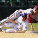 Arizona Diamondbacks shortstop Nick Ahmed falls on top of Colorado Rockies' DJ LeMahieu (9) after throwing to first to complete the double play to out Nick Hundley during the fifth inning of the first game of a baseball double header Tuesday, Sept. 1, 2015, in Denver. (AP Photo/Jack Dempsey)