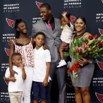 Arizona Cardinals' Adrian Wilson poses with his wife, Alicia, right, daughter Aubrey, second from left, son Santana, center, son Brooklyn, left, and holding daughter Karter after he announced his retirement, Monday, April 20, 2015, at the Cardinals team facility in Tempe, Ariz. (AP Photo/Matt York)
