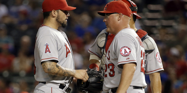 Los Angeles Angels starting pitcher Hector Santiago, left, talks with pitching coach Mike Butcher a...