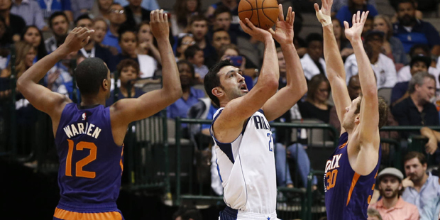 Dallas Mavericks' Zaza Pachulia, middle, shoots between Phoenix Suns' T.J. Warren (12) and Jon Leue...