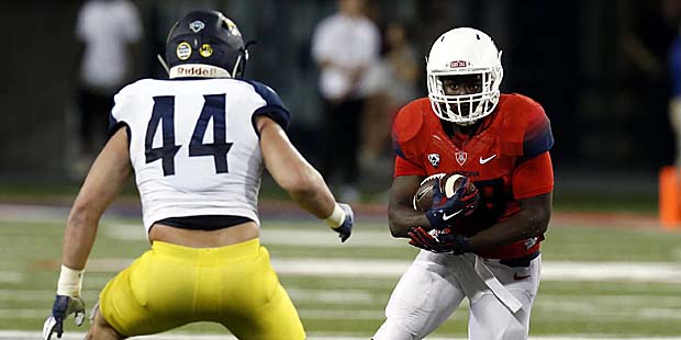 Arizona running back Nick Wilson carries for a first down in front of Northern Arizona linebacker J...