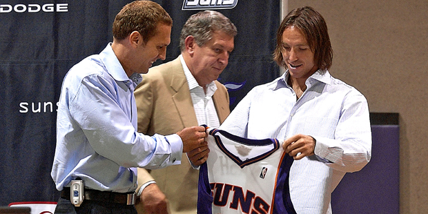 Newly aquired Phoenix Suns guard Steve Nash, right, holds up his new jersey as Suns President Bryan...