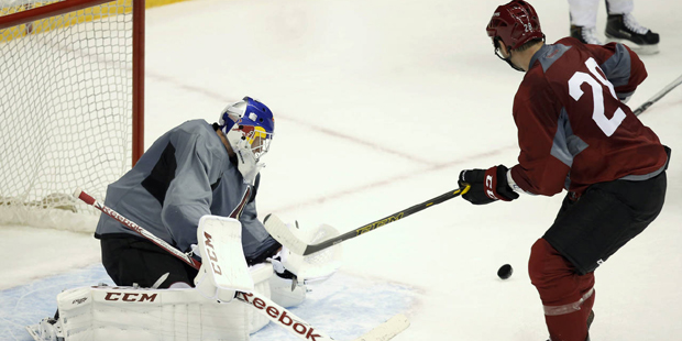 Arizona Coyotes goalie Niklas Treutle, left, makes a save on a shot by John Scott, right, during th...