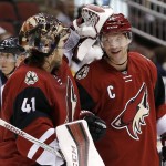 Arizona Coyotes' Shane Doan, right, smiles as he is congratulated by goalie Mike Smith (41) after Doan's goal against the Boston Bruins during the first period of an NHL hockey game Saturday, Oct. 17, 2015, in Glendale, Ariz.  For Doan it was his 900th NHL point. (AP Photo/Ross D. Franklin)
