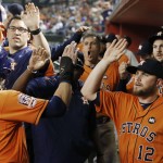Houston Astros' Colby Rasmus, left, celebrates his run scored against the Arizona Diamondbacks with teammates, including Max Stassi (12), during the first inning of a baseball game Friday, Oct. 2, 2015, in Phoenix. (AP Photo/Ross D. Franklin)