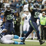 Seattle Seahawks' Cliff Avril (56) celebrates after a play as Carolina Panthers' Jonathan Stewart (28) gets up from the turf in the second half of an NFL football game, Sunday, Oct. 18, 2015, in Seattle. (AP Photo/Elaine Thompson)