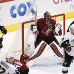 Arizona Coyotes' Mike Smith, middle, raises his arms in celebration as time expires during the third period of an NHL hockey game as Pittsburgh Penguins' David Perron (57) and Chris Kunitz, right, look for the puck Saturday, Oct. 10, 2015, in Glendale, Ariz.  The Coyotes defeated the Penguins 2-1. (AP Photo/Ross D. Franklin)