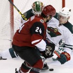 Minnesota Wild's Charlie Coyle (3) collides with Arizona Coyotes' Kyle Chipchura (24) as Wild goalie Devan Dubnyk makes a save during the second period of an NHL hockey game Thursday, Oct. 15, 2015, in Glendale, Ariz. The Wild won 4-3. (AP Photo/Ross D. Franklin)