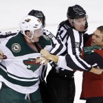 Arizona Coyotes' Steve Downie, right, and Minnesota Wild's Ryan Suter (20) are separated by linesmen Ryan Gibbons (58) and Ryan Galloway (82) during the second period of an NHL hockey game Thursday, Oct. 15, 2015, in Glendale, Ariz. Minnesota won 4-3. (AP Photo/Ross D. Franklin)