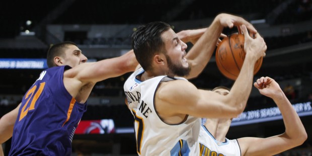 Denver Nuggets forward Joffrey Lauvergne, center, of France, pulls in a rebound in front of Nuggets...