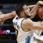 Denver Nuggets forward Joffrey Lauvergne, center, of France, pulls in a rebound in front of Nuggets center Nikola Jokic, of Serbia, back right, and Phoenix Suns center Alex Len, of the Ukraine, in the first half of an NBA preseason basketball game Friday, Oct. 16, 2015, in Denver. (AP Photo/David Zalubowski)