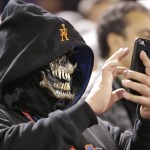 A fan takes a picture with his phone during the fifth inning of Game 4 of the Major League Baseball World Series between the New York Mets and the Kansas City Royals Saturday, Oct. 31, 2015, in New York. (AP Photo/David J. Phillip)