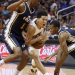 Phoenix Suns' Devin Booker, middle, is defended by Utah Jazz's Alec Burks, left, and Rodney Hood, right during the first half of an NBA preseason basketball game Friday, Oct. 9, 2015, in Phoenix. (AP Photo/Ross D. Franklin)