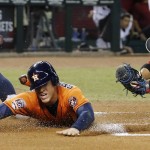 Houston Astros' George Springer, left, scores a run ahead of the tag by Arizona Diamondbacks' Welington Castillo, right, during the first inning of a baseball game Friday, Oct. 2, 2015, in Phoenix. (AP Photo/Ross D. Franklin)
