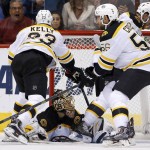 Boston Bruins' Tuukka Rask, bottom, of Finland, gives up a goal to Arizona Coyotes' Shane Doan as Bruins' Chris Kelly (23) and Tommy Cross (56) look for the puck as they defend during the first period of an NHL hockey game Saturday, Oct. 17, 2015, in Glendale, Ariz. (AP Photo/Ross D. Franklin)