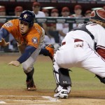 Houston Astros' George Springer, left, dives around Arizona Diamondbacks' Welington Castillo, right, to score a run during the first inning of a baseball game Friday, Oct. 2, 2015, in Phoenix. (AP Photo/Ross D. Franklin)