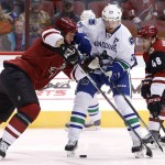 Vancouver Canucks' Henrik Sedin (33), of Sweden, tries to get the puck past Arizona Coyotes' Nicklas Grossmann, left, of Sweden, and Jordan Martinook (48) during the first period of an NHL hockey game Friday, Oct. 30, 2015, in Glendale, Ariz. (AP Photo/Ross D. Franklin)