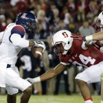 Arizona quarterback Jerrard Randall, left, evades a tackle from Stanford's Conrad Ukropina, center, and Joey Alfieri during the first half of an NCAA college football game Saturday, Oct. 3, 2015, in Stanford, Calif.  (AP Photo/Marcio Jose Sanchez)
