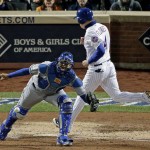 New York Mets' Wilmer Flores, right, scores past Kansas City Royals catcher Salvador Perez on a sacrifice fly ball by Curtis Granderson during the thrid inning of Game 4 of the Major League Baseball World Series Saturday, Oct. 31, 2015, in New York. (AP Photo/Charlie Riedel)