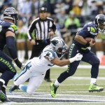 Seattle Seahawks quarterback Russell Wilson, right, tries to get away from Carolina Panthers defensive tackle Star Lotulelei, center, in the first half of an NFL football game, Sunday, Oct. 18, 2015, in Seattle. (AP Photo/Stephen Brashear)
