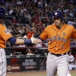 Houston Astros' Carlos Correa (1) slaps hands with Colby Rasmus (28) after Correa hit a home run against the Arizona Diamondbacks during the fourth inning of a baseball game Friday, Oct. 2, 2015, in Phoenix. (AP Photo/Ross D. Franklin)