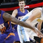 Phoenix Suns guard Archie Goodwin, front, reaches back to steal a pass intended for Denver Nuggets center Nikola Jokic, center, as Suns forward Mirza Teletovic watches during the second half of an NBA basketball game Friday, Oct. 16, 2015, in Denver. The Nuggets won 106-81. (AP Photo/David Zalubowski)