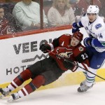 Arizona Coyotes' Oliver Ekman-Larsson (23), of Sweden, crashes into the boards in front of Vancouver Canucks' Alex Burrows (14) during the third period of an NHL hockey game Friday, Oct. 30, 2015, in Glendale, Ariz. The Canucks defeated the Coyotes 4-3. (AP Photo/Ross D. Franklin)