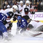 Arizona Coyotes goaltender Mike Smith, right, makes a save against Toronto Maple Leafs' Shawn Matthias (23) as Maple Leafs' Mark Arcobello (33) Coyotes' Boyd Gordon (15) and Zbynek Michalek (4) look for a rebound during second period NHL hockey action in Toronto on Monday, Oct. 26, 2015. (Frank Gunn/The Canadian Press via AP)