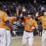 Houston Astros' Colby Rasmus, second from right, sticks his tongue out as he celebrates hit two-run home run against the Arizona Diamondbacks with teammates Carlos Correa, right, Chris Carter (23) and Luis Valbuena, second from left, during the sixth inning of a baseball game Friday, Oct. 2, 2015, in Phoenix. (AP Photo/Ross D. Franklin)